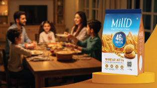 A family enjoying dinner together at a table with a pack of Milld high-protein atta shown beside them, highlighting that the flour offers the same taste with better nutrition from all 9 essential amino acids